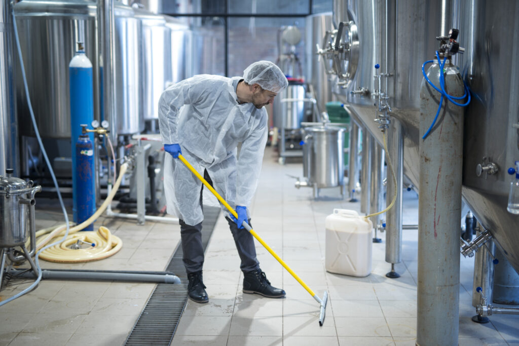 An expert performing commercial pest control dublin services in a spotless restaurant kitchen environment.

